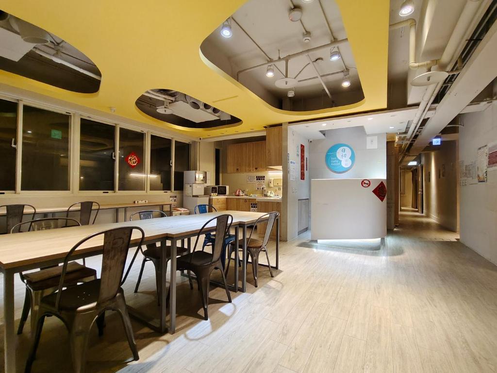 eine Cafeteria mit einem Tisch und Stühlen sowie eine Küche in der Unterkunft 日初青旅 Sundaily Hostel 北車 in Taipeh