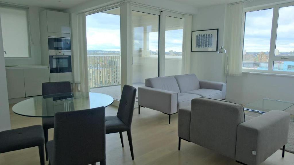 ein Wohnzimmer mit einem Glastisch und Stühlen in der Unterkunft Luxury 2B2B in central London in London