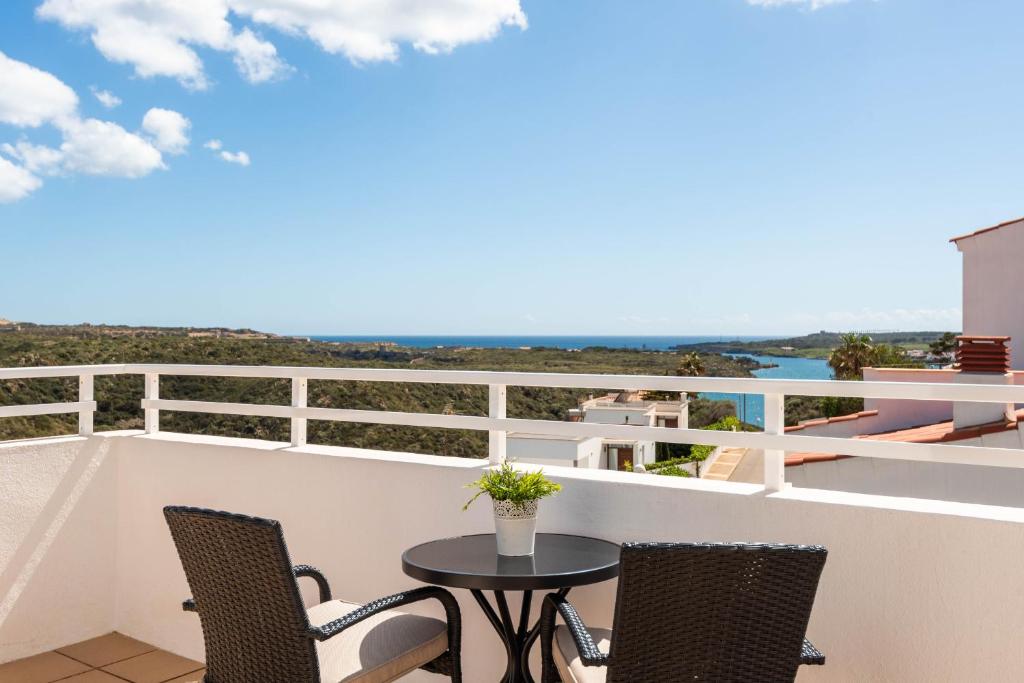 balcón con mesa, sillas y vistas al océano en Villa Cayetana en Mahón