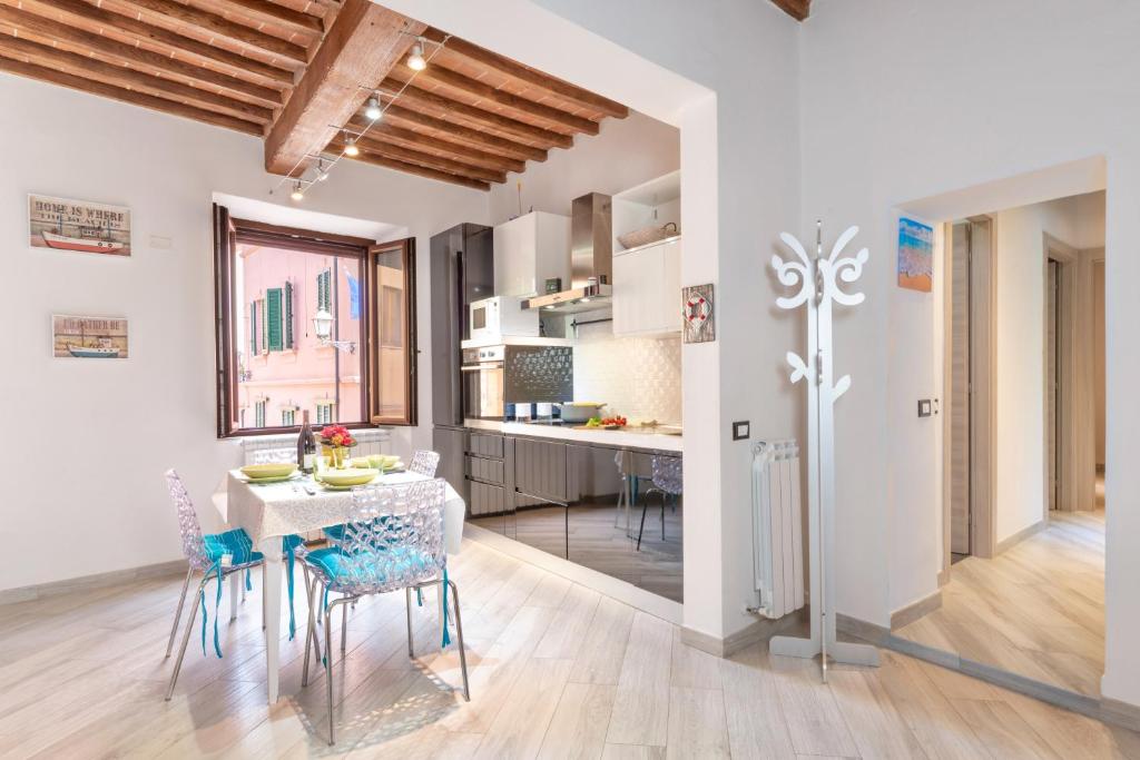 a kitchen and dining room with a table and chairs at Piombino Apartments - Casa XX Settembre in Piombino