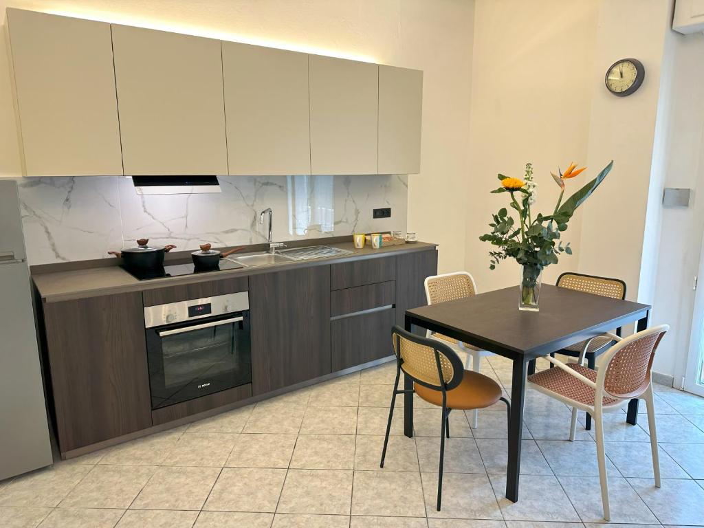 une cuisine avec une table, des chaises et un évier dans l'établissement La Papera Sciocca, à La Spezia