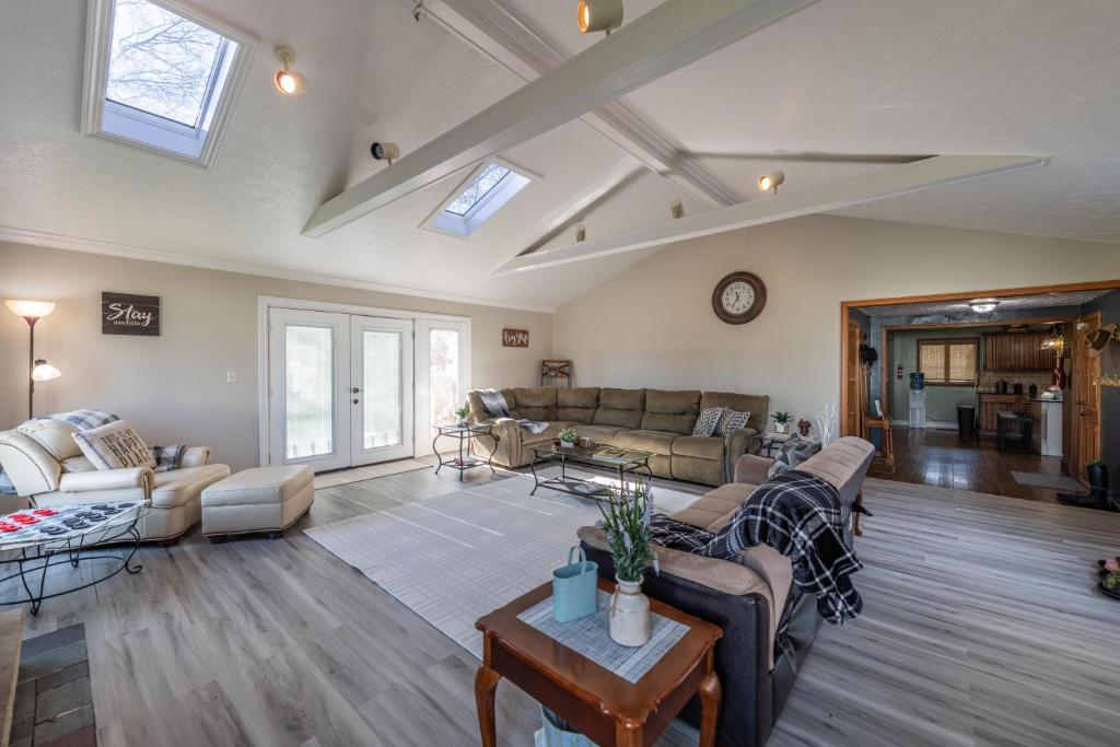 a living room with couches and a table at Maplewood Farmhouse + Hot tub in Howland Corners