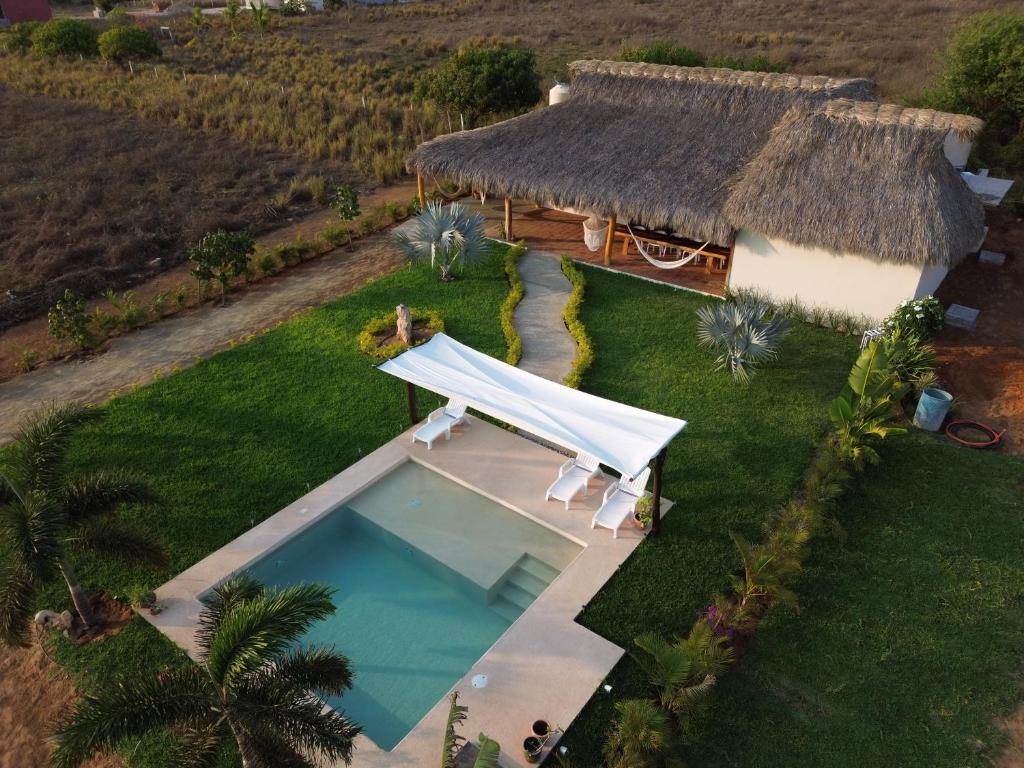 an overhead view of a house with a pool and a thatch roof at Casa Carey Villa en la Playa in Tlachicón
