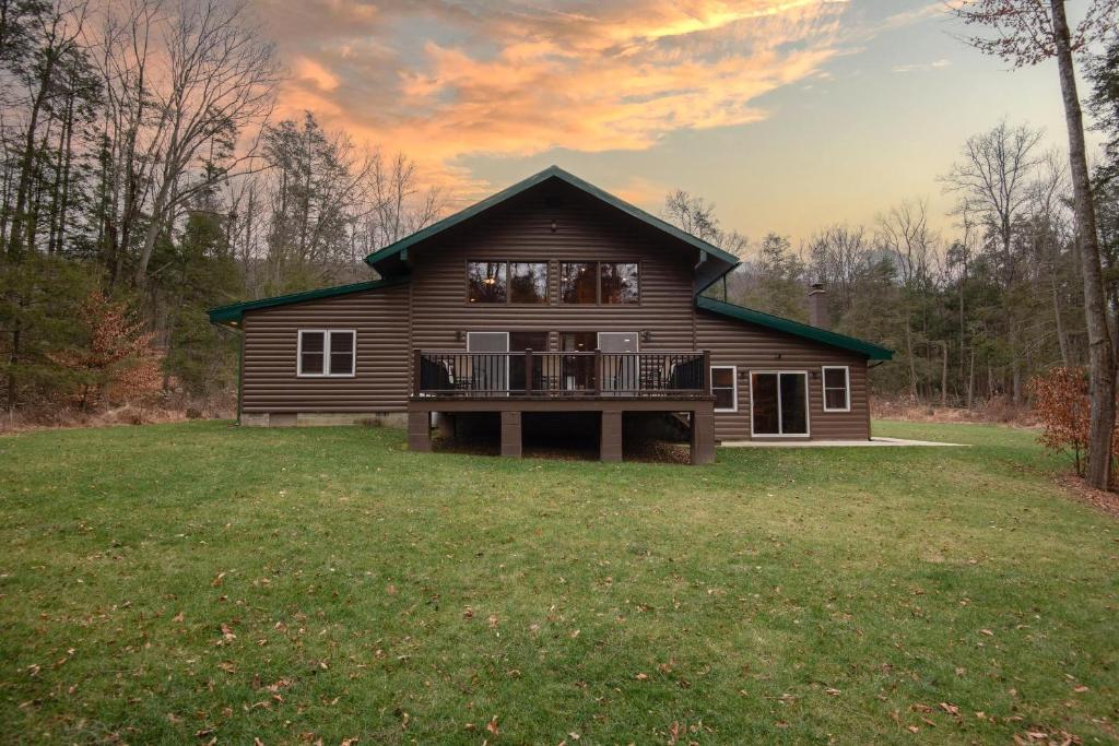 a log house with a deck on a yard at Fisher Mountain Retreat 