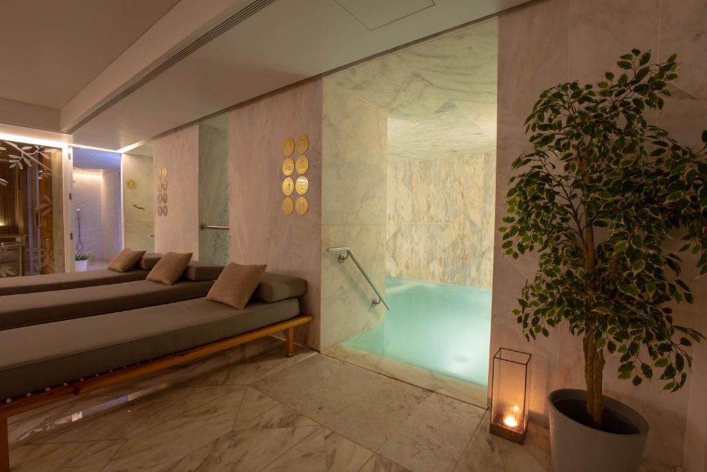 a bathroom with a couch and a tub with a plant at Lisboa Pessoa Hotel in Lisbon