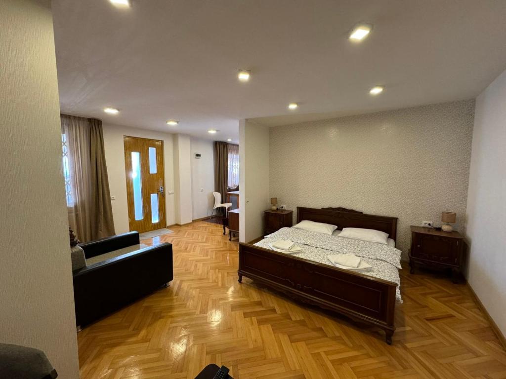 a bedroom with a bed and a couch in it at K&N Guesthouse in Tbilisi City
