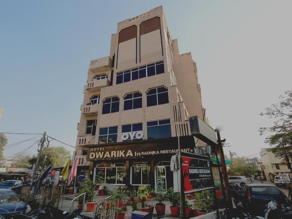 Un palazzo alto con un cartello davanti di OYO Hotel Dwarika Inn a Jabalpur