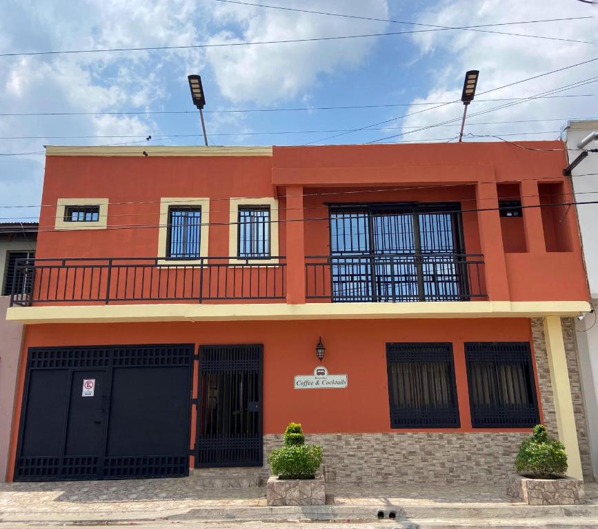 a orange building with black doors and windows at Hospedaje Coffee and cocktails in Estelí