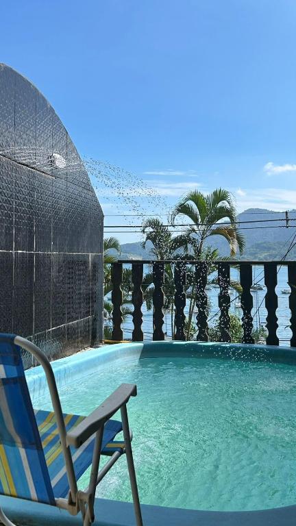 una silla sentada junto a una piscina en Mansão Espetacular Angra, en Angra dos Reis