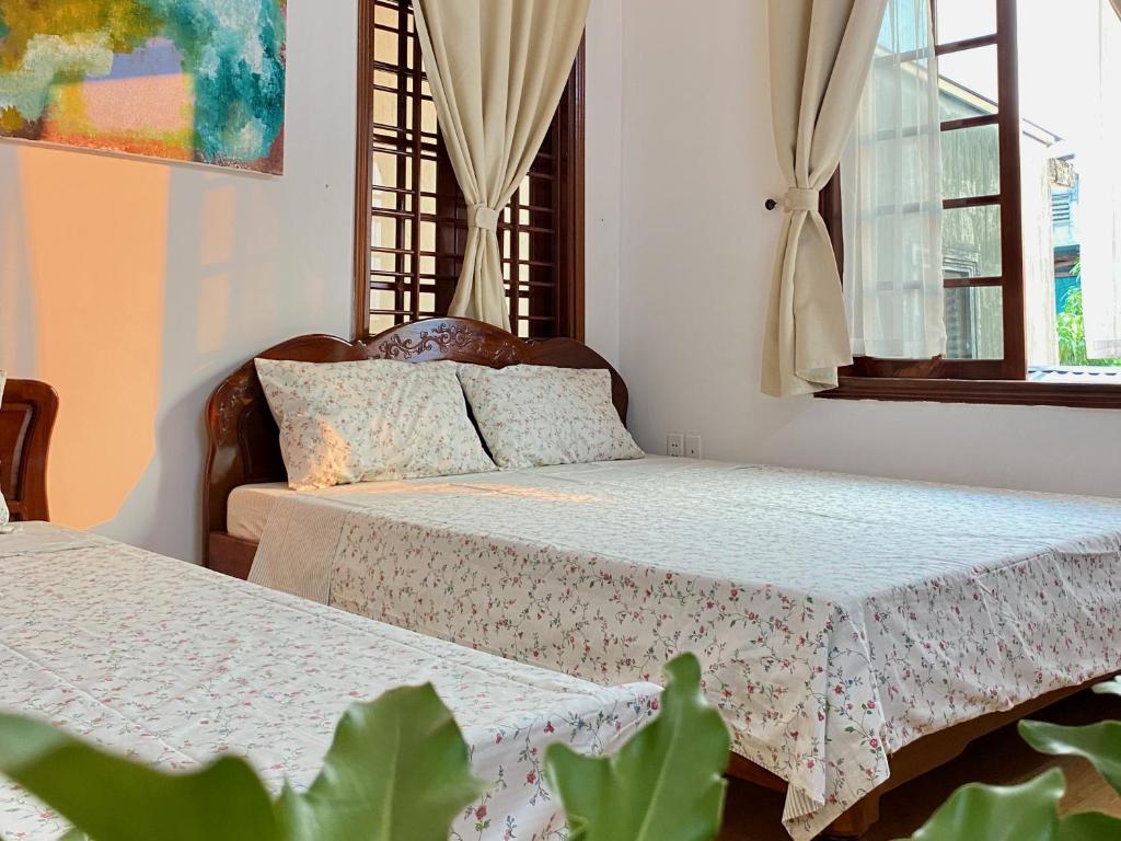 - une chambre avec deux lits et une plante dans l'établissement ký ức tươi đẹp homestay, à Hue