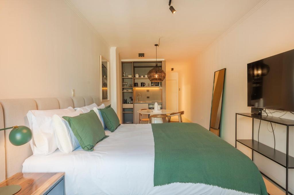 Un dormitorio con una gran cama blanca con almohadas verdes. en Viví y Disfrutá el Lujo en Torre Decó Recoleta Armani powered by Argenhost -902-, en Buenos Aires