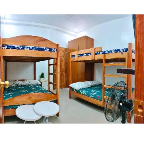 a room with two bunk beds and a table at City Center Transient House - Studio Type in Baguio