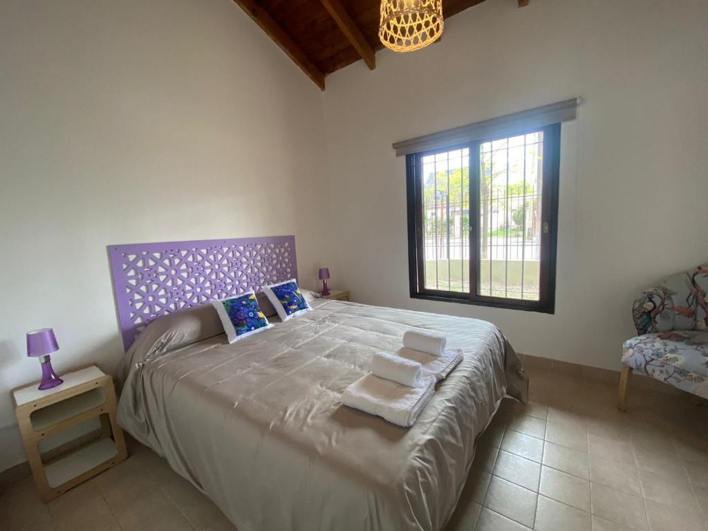 Un dormitorio con una cama grande y una ventana. en Las Balda, tu casita en Viedma, en Viedma