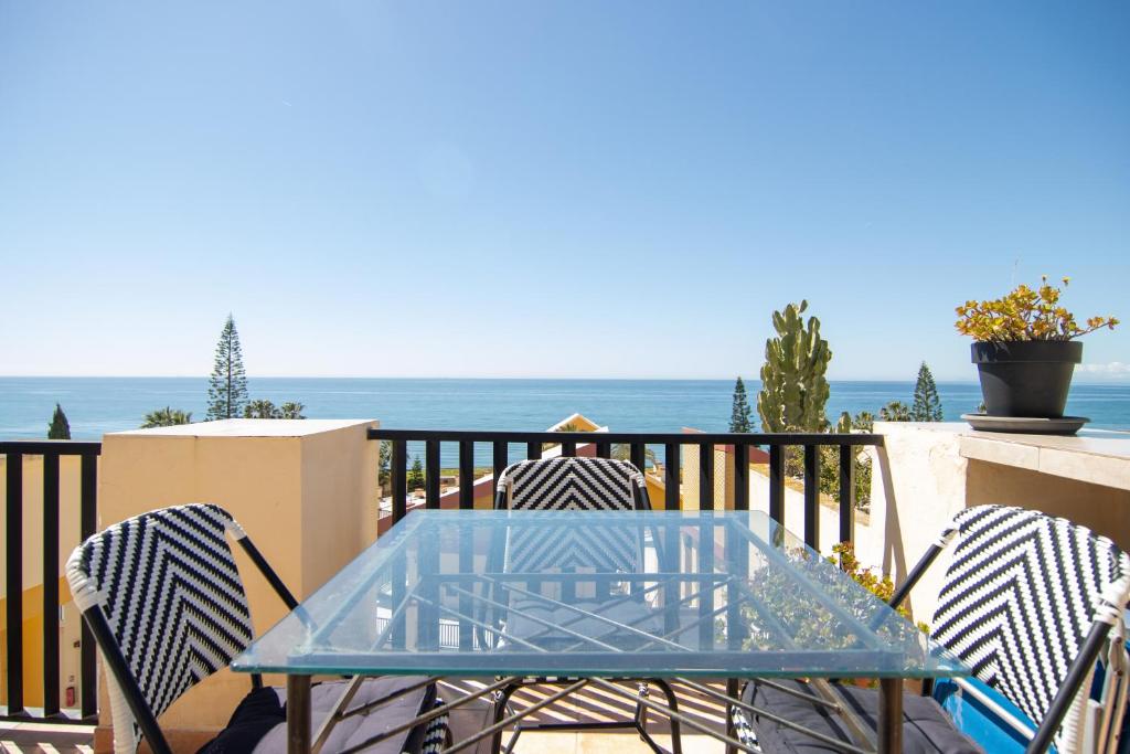 einen Tisch und Stühle auf einem Balkon mit Meerblick in der Unterkunft OleHolidays 655 Romana Playa vistas al mar in Marbella