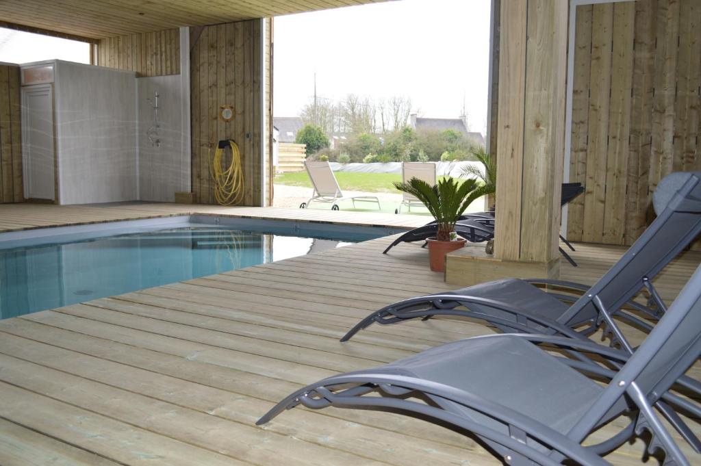 una terraza con sillas y una piscina en Gîte de LANVIAN en Guissény