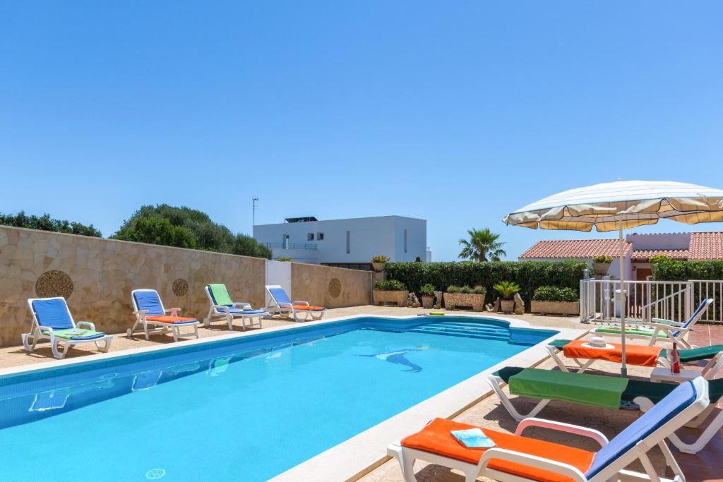 a swimming pool with chaise lounge chairs and a swimming pool at Villa Sol Menorca in Punta Prima