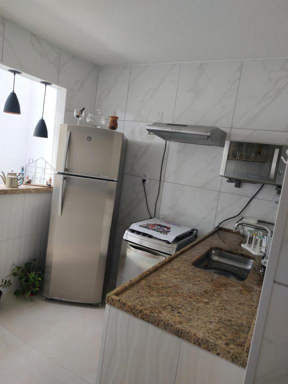 uma cozinha com um frigorífico e uma bancada em Casa para Temporada em Resende