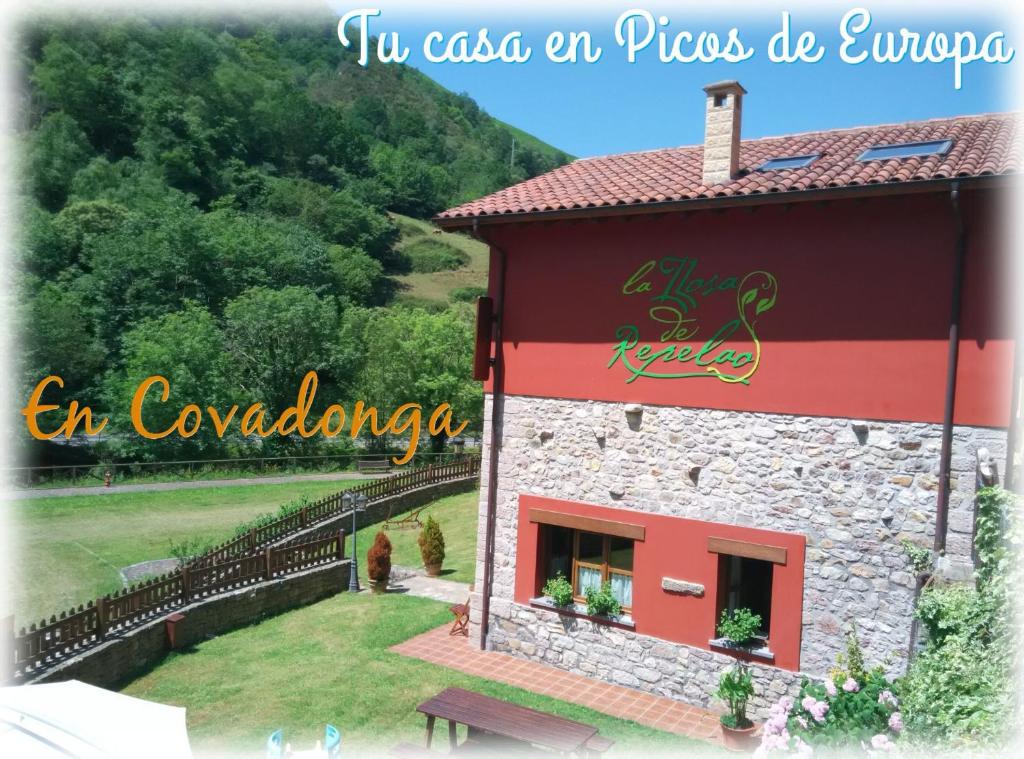 un bâtiment avec un panneau sur son côté dans l'établissement La Llosa de Repelao, à Covadonga
