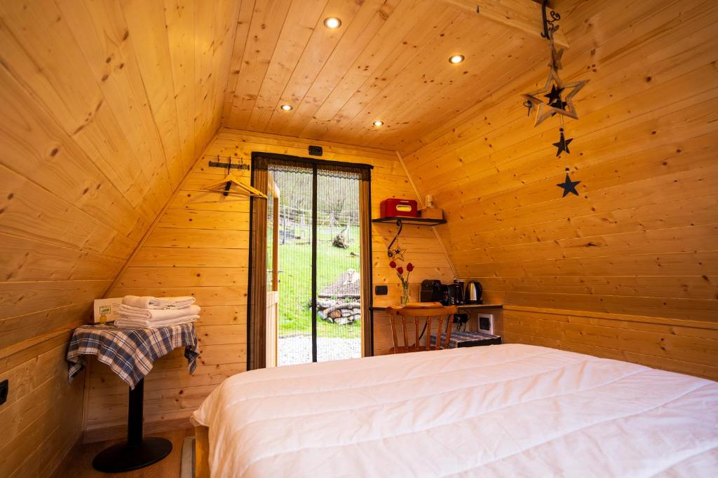 a bedroom with a bed in a wooden cabin at Baita Eleonora in Argegno