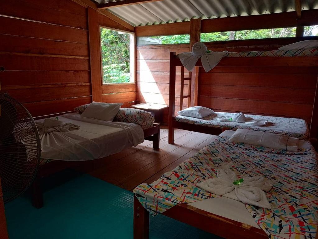 a room with two beds and a table and chairs at Casa hostal playa coral in Capurganá