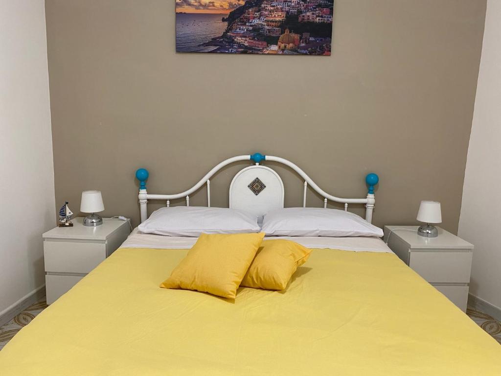1 dormitorio con 1 cama amarilla y 2 almohadas amarillas en Casa vacanza: The Wind Rose, en Vietri