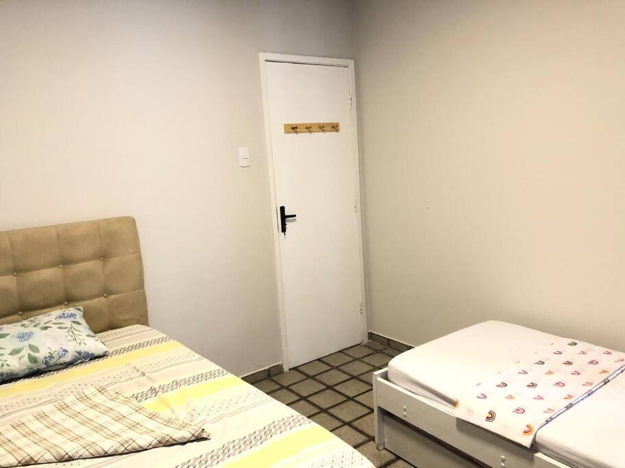 a small bedroom with two beds and a door at Flat mobiliado na rua da Aurora in Recife