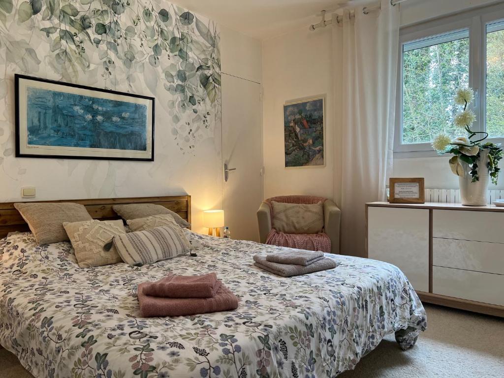 ein Schlafzimmer mit einem Bett mit zwei Kissen darauf in der Unterkunft Le Bois des Sources in Saint-Marcel