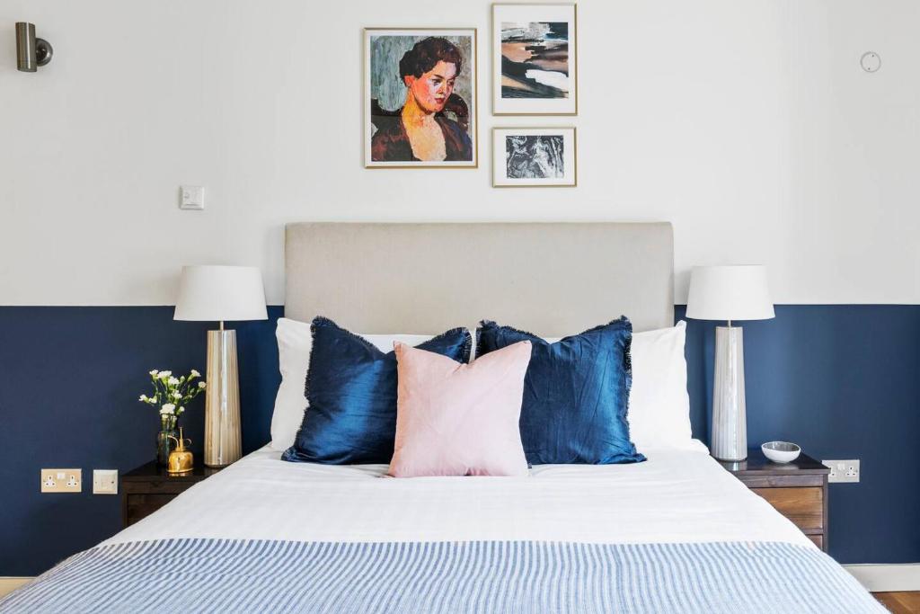 a bedroom with a blue and white bed with pillows at Hoxton Square - Urban Haven in London
