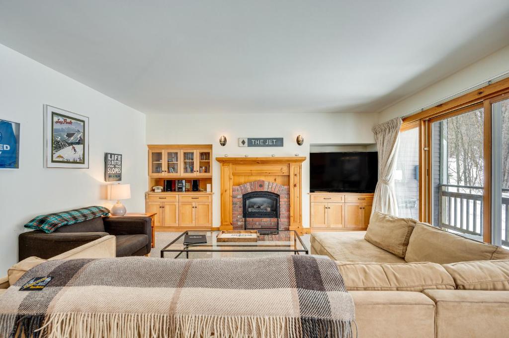 sala de estar con sofá y chimenea en Ski-In Resort Family Condo with Deck at Jay Peak!, en Jay