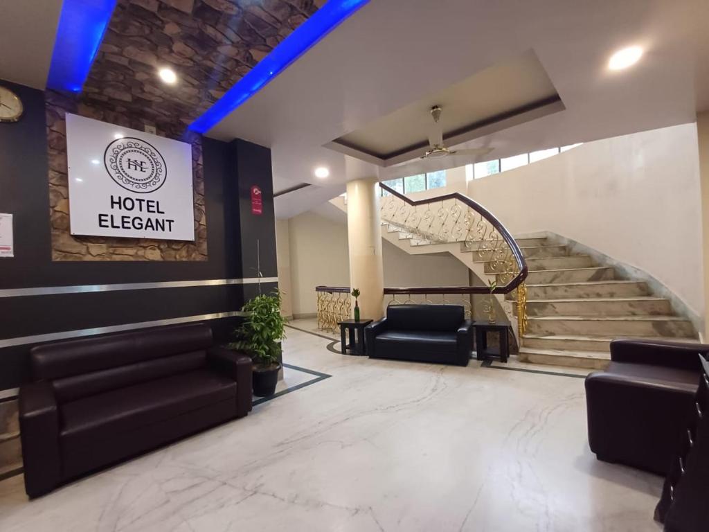 a hotel lobby with chairs and a spiral staircase at Hotel Elegant in Dimāpur