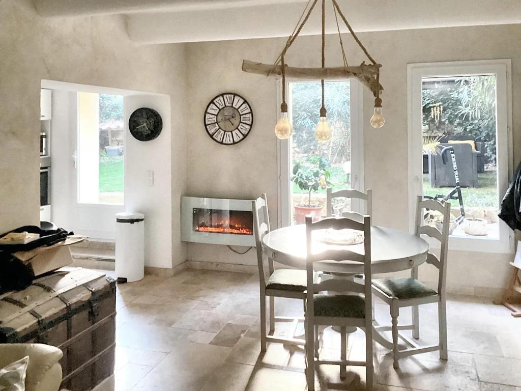 uma sala de jantar com uma mesa e cadeiras e uma lareira em Appartement de 3 chambres avec hammam jardin clos et wifi a Aix en Provence em Aix-en-Provence