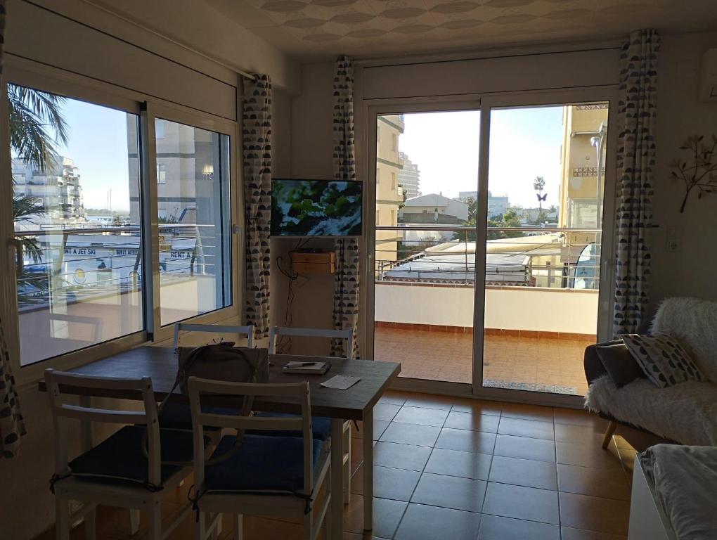 un soggiorno con tavolo e sedie e un balcone di APCOSTAS - Puerto Simona a Roses