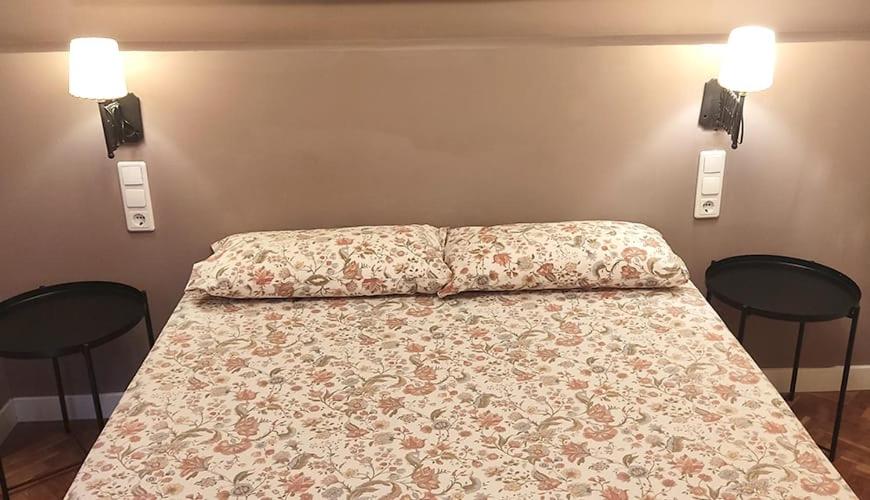 un letto in una camera da letto con due sedie nere di Apartamentos "Casa Melé" 3, Parking privado opcional a Lleida