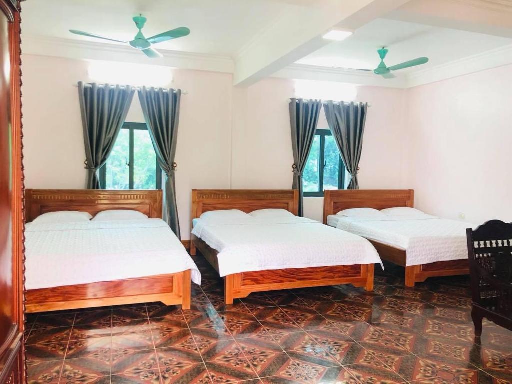 três camas num quarto com três janelas em Khách sạn Hoa Biển A em Xóm Côn