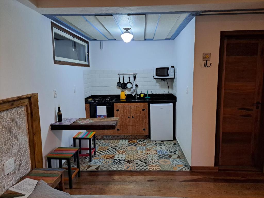 拉夫拉斯魯巴的住宿－Chalé Antúrios - Lavras Novas，厨房配有桌子和冰箱