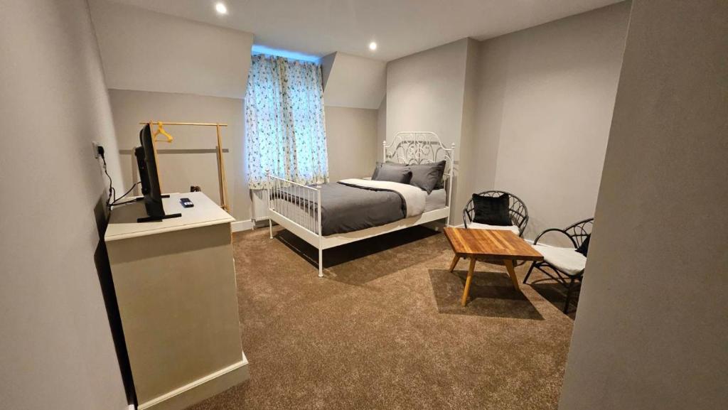 a bedroom with a bed and a television and a table at Thames Ditton Surrey in Thames Ditton