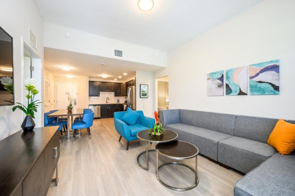 a living room with a gray couch and blue chairs at New Modern Vista Cay Reserve Condo - 5006 in Orlando