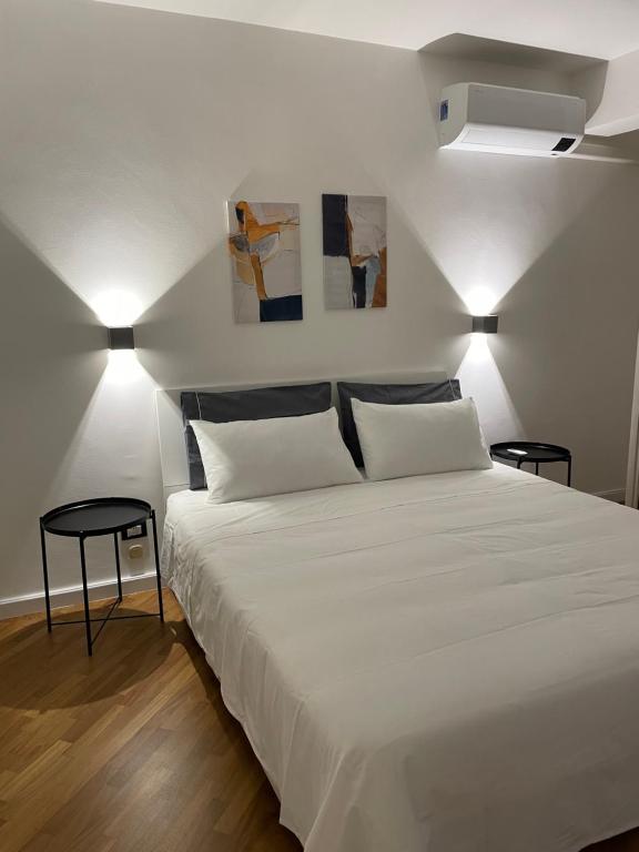 ein Schlafzimmer mit einem großen weißen Bett mit zwei Lampen in der Unterkunft Baaria house in Bagheria