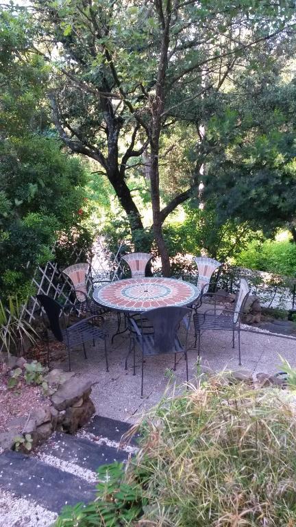 une table et des chaises assises sous un arbre dans l'établissement Saint-Raphaël Villa mitoyenne 10 min de la plage, à Saint-Raphaël