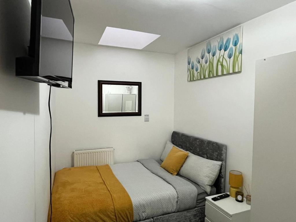 a small bedroom with a bed and a television at Home Away in London