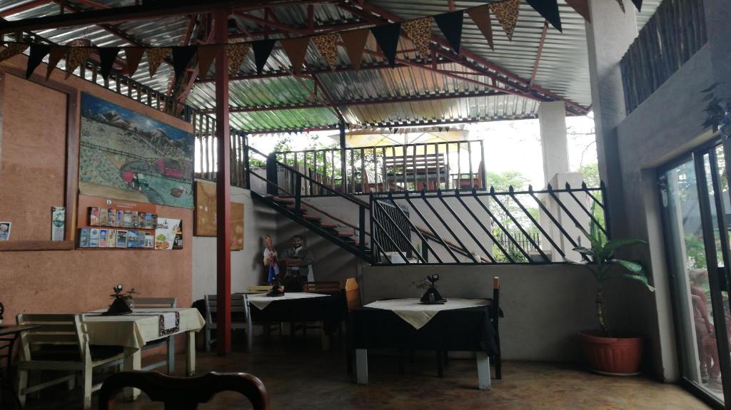 a restaurant with tables and a staircase in the ceiling at the FARMHOUSE BOUTIQUE GUESTHOUSE AND BEERGARDEN CC in Outjo