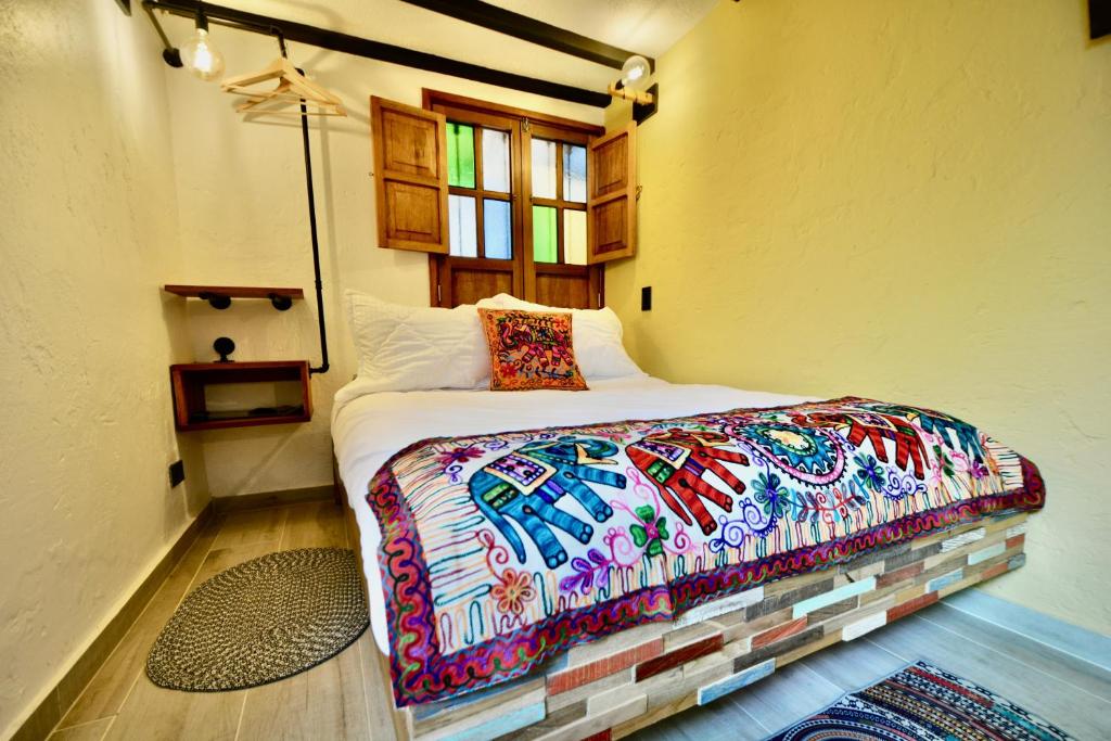 ein Schlafzimmer mit einem Bett mit einer bunten Bettdecke in der Unterkunft Casa Moline Blue in Bogotá