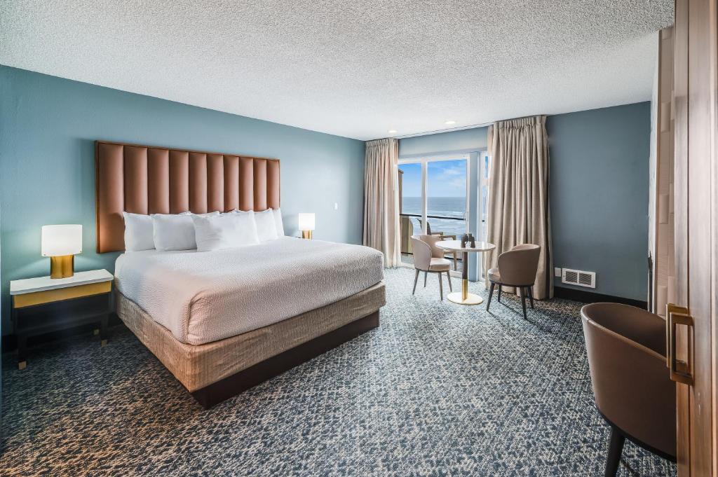 um quarto de hotel com uma cama, uma mesa e cadeiras em The Whaler em Newport