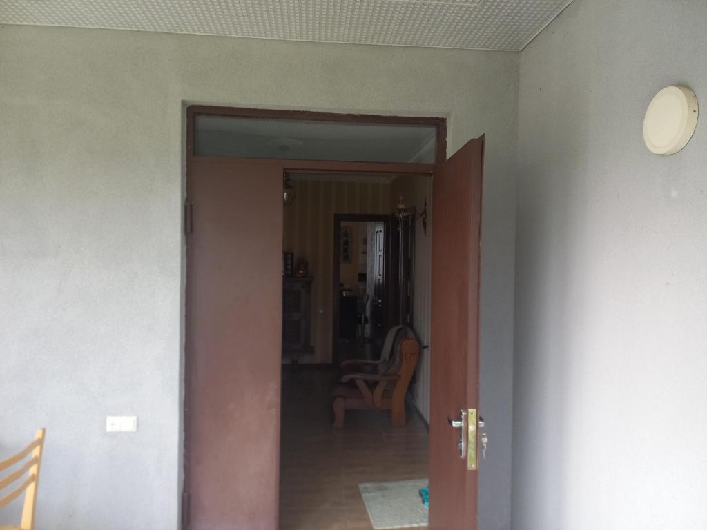 um corredor com uma porta aberta para um quarto em House in the garden. Sachkhere. em Ssatschcheri