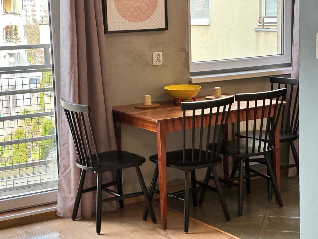 a dining room table with chairs and a bowl on it at Apartament Szafranowy in Wrocław