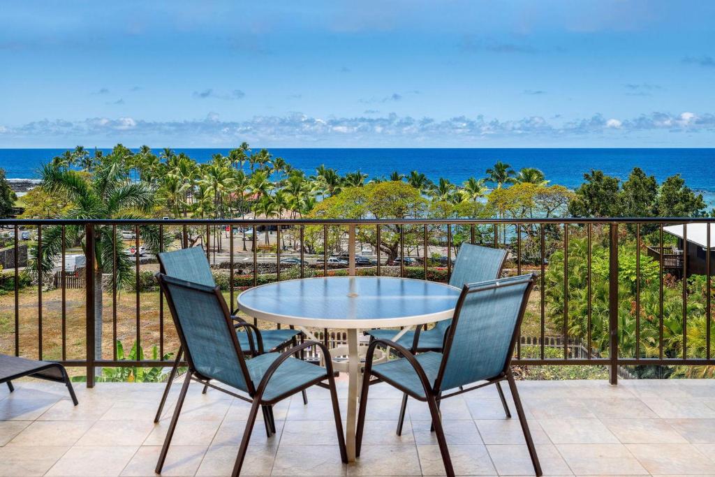 einen Tisch und Stühle auf einem Balkon mit Meerblick in der Unterkunft Kahaluu Bay Villas 304 in Kailua-Kona