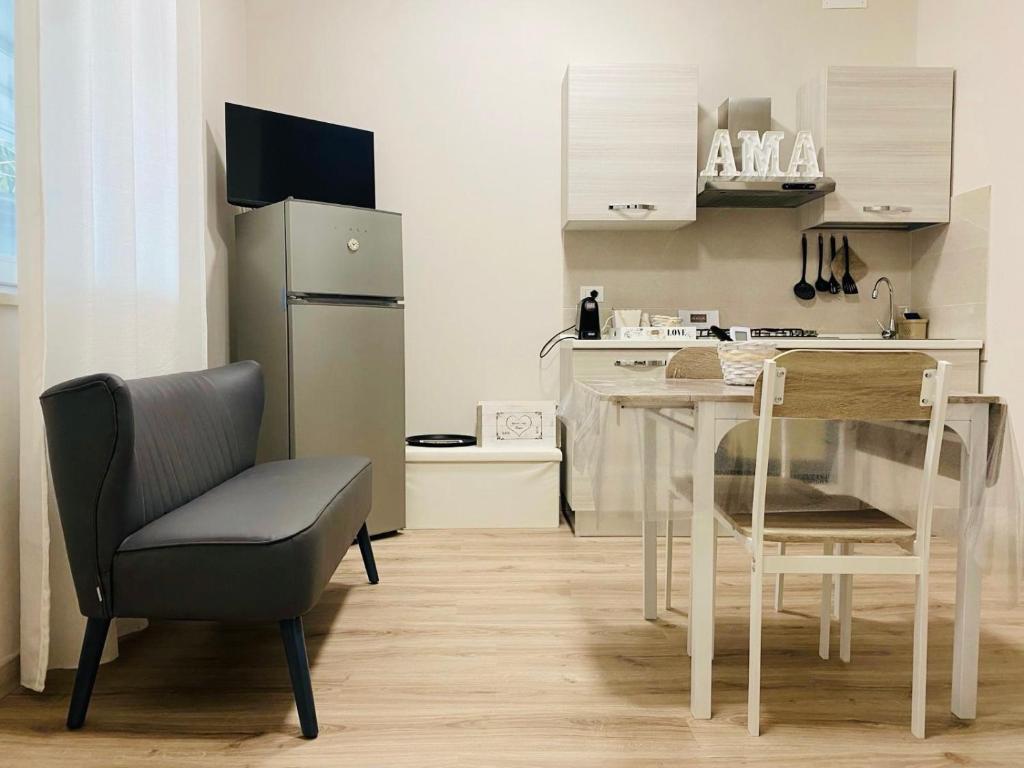 a kitchen with a glass table and a chair at AMA B&B in Montesilvano