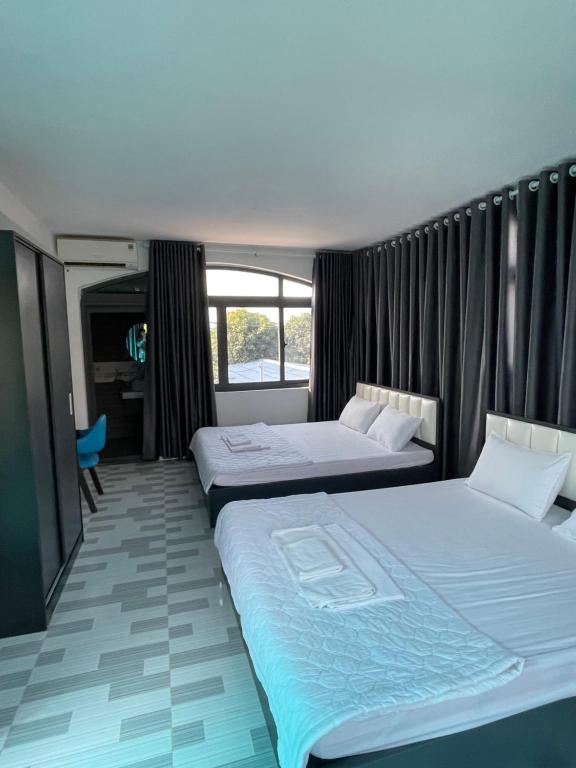 een hotelkamer met 2 bedden en een raam bij homestay 252 Long Hải in Ấp Lò Vôi