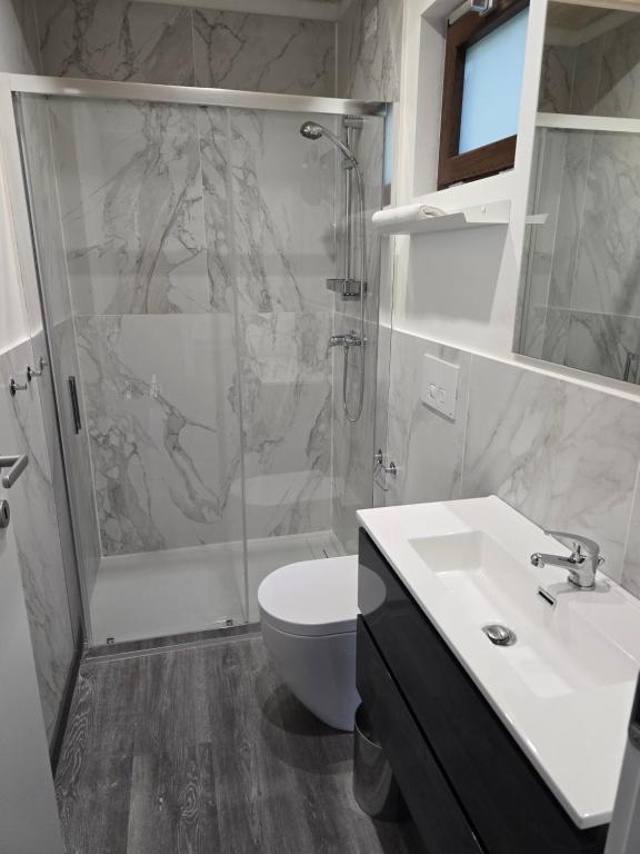 a bathroom with a shower and a sink and a toilet at Campeggio Gianna Golfo dei Poeti in Lerici