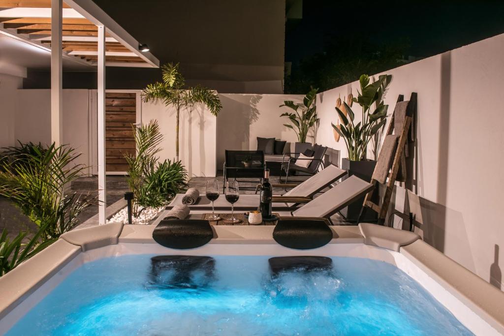 a swimming pool with two chairs and a living room at Icos City 1 in Hersonissos
